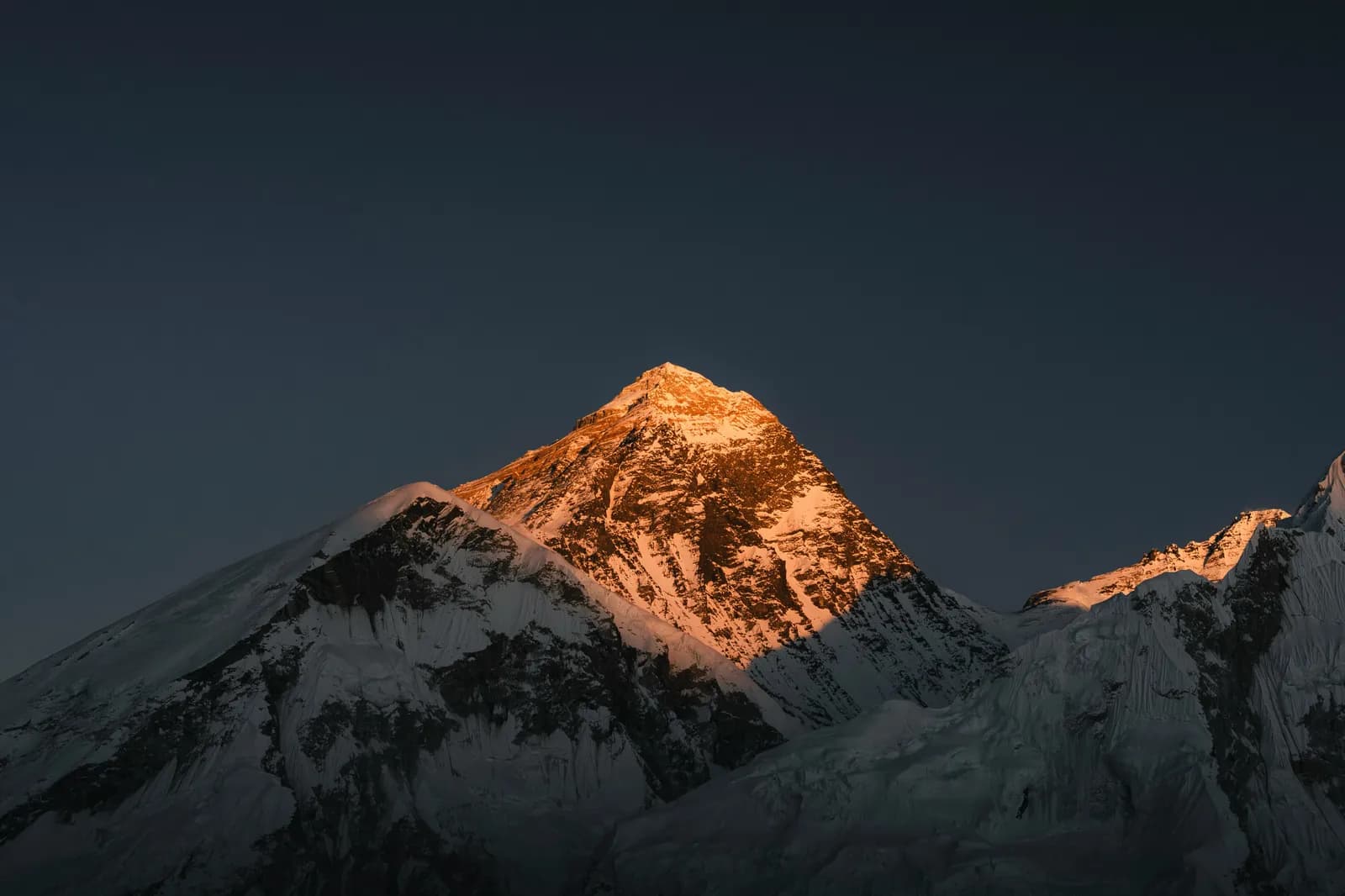 Snow-covered Himalayan peaks glowing gold in the early morning sunrise