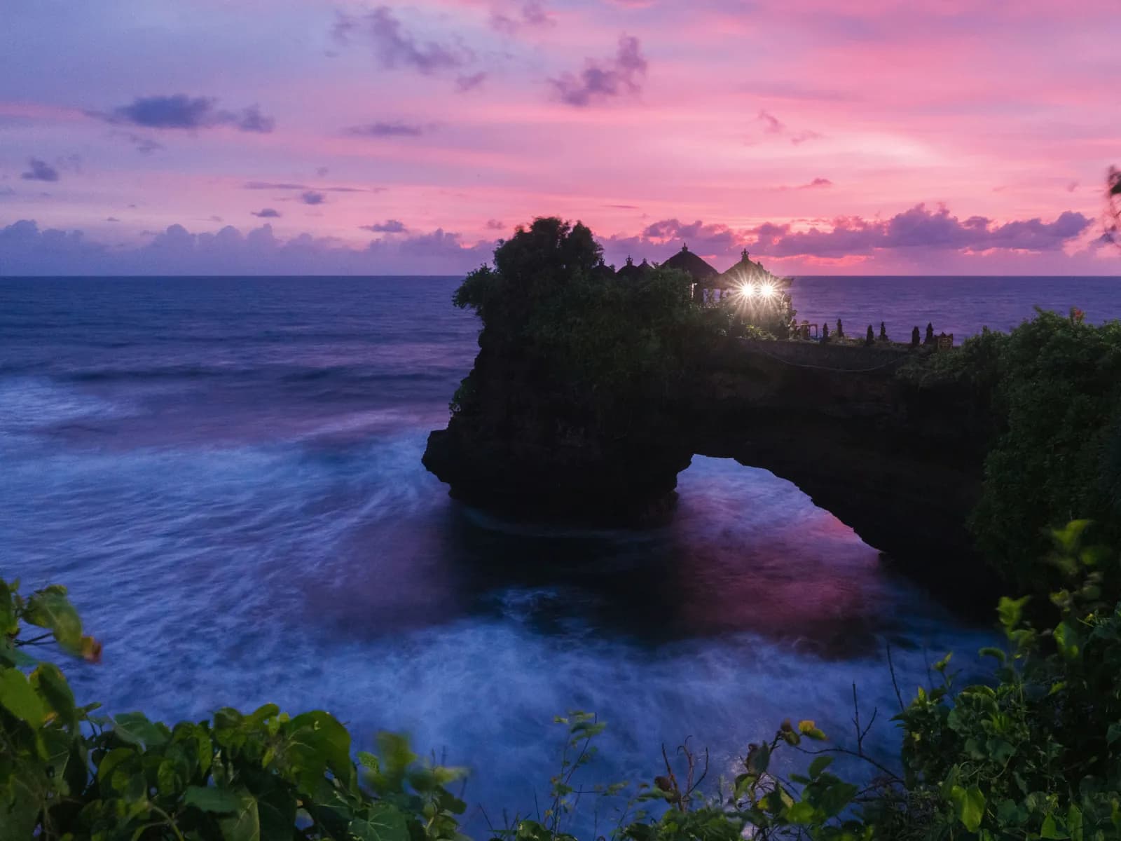 Tanah Lot temple on its rock outcrop above the sea at sunset